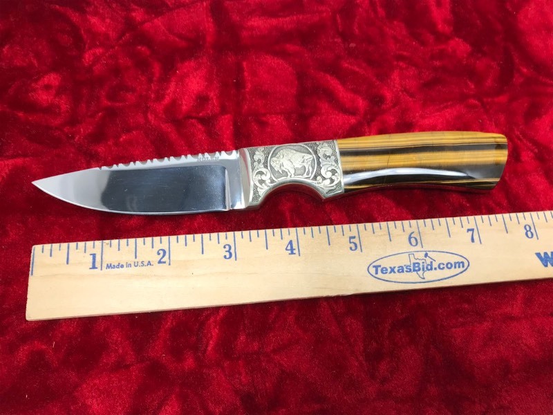 lot 114 image: Custom Knife  Maker  (RD or George ) Nolen, Engraved Buffalo & Indian, Drop Point Hunter, Tiger Eye Handle and Filework,  approx. 8 in. overall.
