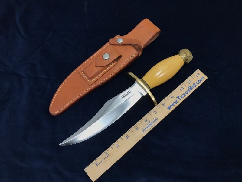 lot 130 image: Custom Knife  Maker Randall Knives,  Model 12 Bear Bowie,  Micarta handle with brass fittings, includes sheath,  approx. 13 in. overall.