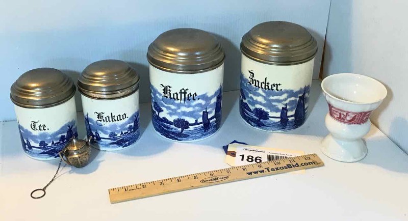 lot 186 image: 4-Piece Porcelain Delft Canister Set (Kakao, Zucker, Kaffe, Tee) & (1) Heinrich Cup