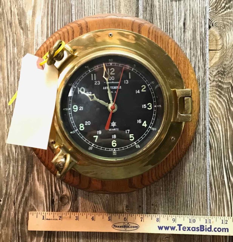 lot 318 image: Ships Porthole Brass Clock (11� in. diameter on wood)
