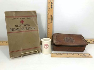 lot 828 image: The Zip Kit, I.A. Kutzer with Texaco Emblem (leather), Red Cross Home Nursing Book 1942, US Army Creamer