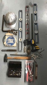 lot 117 image: Assorted tools, helmet, clamp, levels, canvas pliers, etc.