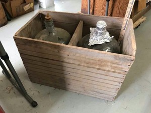 lot 143 image: (2) large glass bottles in old bead board crate