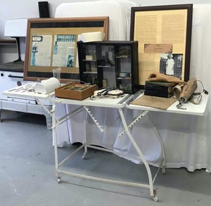 lot 52 image: Historic Boerne  Lex Sanitorium Collectibles, ca. early 1900s Antique Adjustable Operating Table, Medical Tools, Old Books, Nurses Hat, Etc.